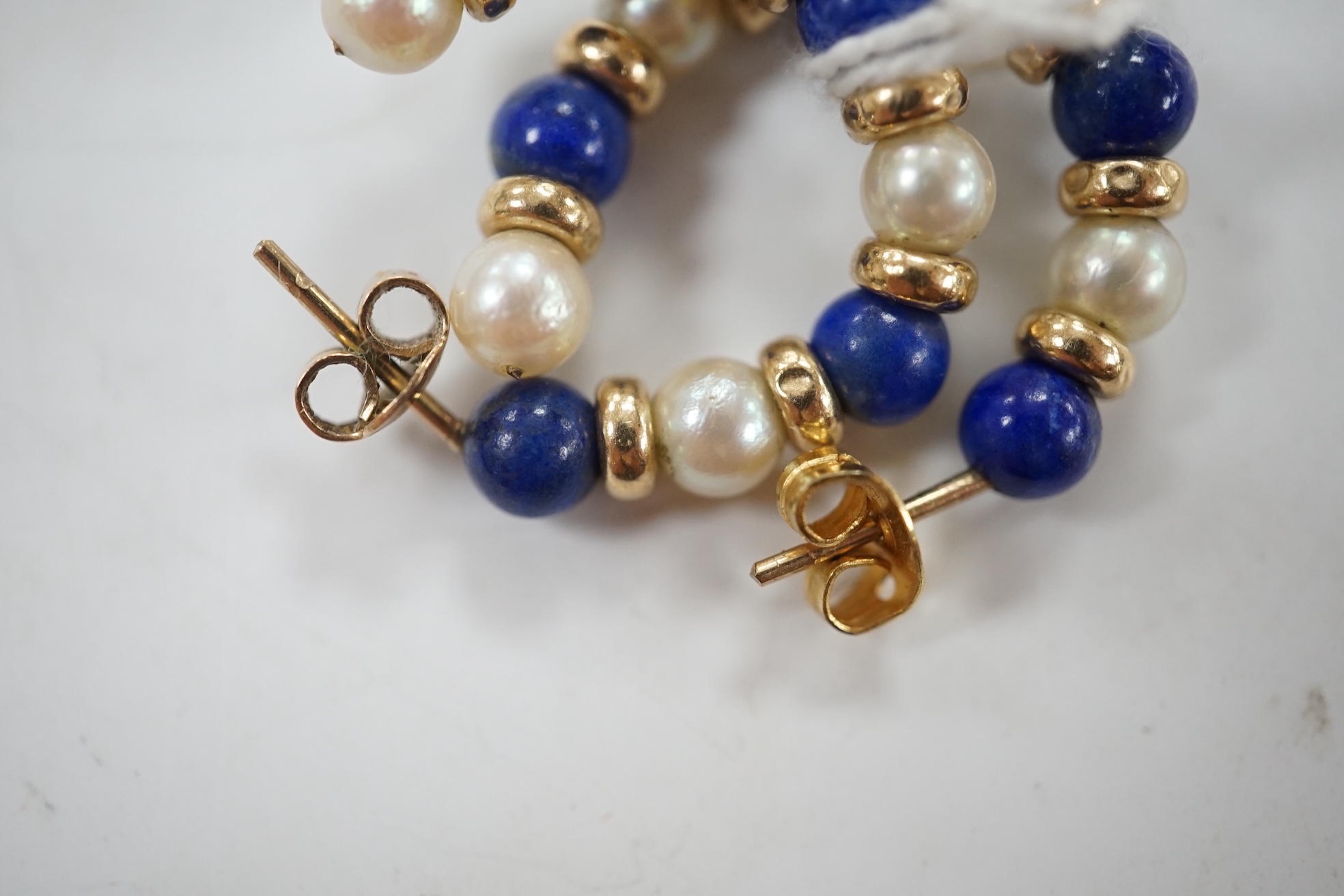 A modern pair of yellow metal lapis lazuli and and cultured pearl cluster set half hoop earrings, 25mm. Condition - fair to good